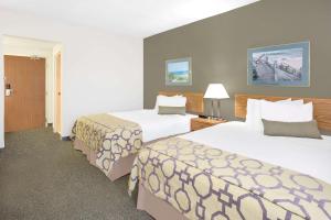 ein Hotelzimmer mit 2 Betten und einer Lampe in der Unterkunft Baymont by Wyndham Janesville in Janesville