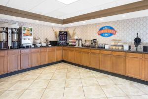 a large kitchen with wooden cabinets in a restaurant at Baymont by Wyndham Janesville in Janesville