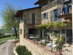Mombarcaro的住宿－Villa Vignotti，街道上一座石头建筑,上面有盆栽植物