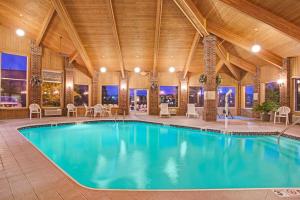 a large swimming pool in a building with a wooden ceiling at Baymont by Wyndham Indianapolis in Indianapolis