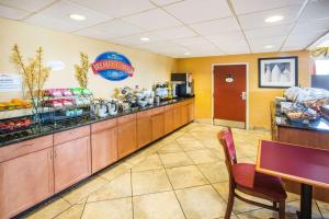 a fast food restaurant with a counter and a table at Baymont by Wyndham Mobile/ I-65 in Mobile
