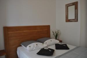 a bed with two pillows and a mirror on the wall at Villa farniente in Le Lavandou