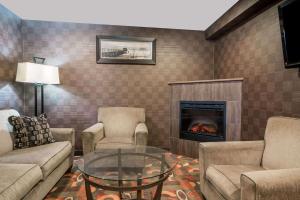 Baymont by Wyndham Eau Claire WI في أو كلير: غرفة معيشة مع أريكة ومدفأة