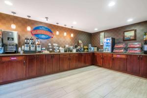 a coffee shop with wooden cabinets and a counter at Baymont by Wyndham Eau Claire WI in Eau Claire