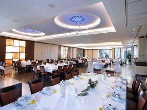a dining room with white tables and chairs at Hotel zur Post in Wettringen