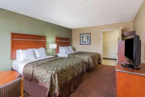 a hotel room with two beds and a flat screen tv at Baymont by Wyndham Pigeon Forge near Island Drive in Pigeon Forge