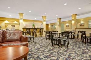 a hotel lobby with tables and chairs and a bar at Baymont by Wyndham Wahpeton in Wahpeton