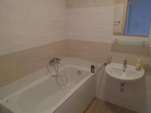 a bathroom with a bath tub and a sink at Fantastic brand new apartment in Podgorica