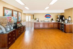a large room with a kitchen with wooden floors at Baymont by Wyndham Grenada in Grenada