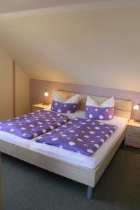 a bedroom with a large bed with purple sheets and pillows at Ferienhof BauerMüller in Fehmarn
