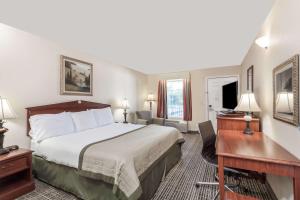 a hotel room with a bed and a desk at Baymont by Wyndham Hickory in Hickory