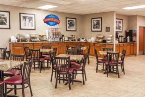 a restaurant with tables and chairs and a counter at Baymont by Wyndham Michigan City in Michigan City