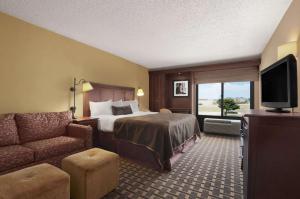 ルイスビルにあるBaymont by Wyndham Lewisvilleのベッドとソファのあるホテルの部屋