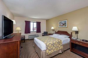 a hotel room with a bed and a flat screen tv at Baymont by Wyndham Metropolis in Metropolis