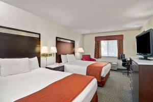 a hotel room with two beds and a flat screen tv at Baymont by Wyndham Washington Court House in Jeffersonville