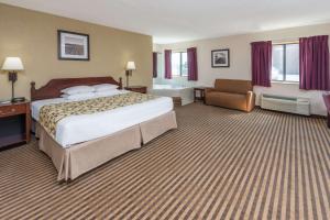 A bed or beds in a room at Baymont by Wyndham Metropolis