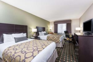 a hotel room with two beds and a flat screen tv at Baymont by Wyndham Cambridge in Cambridge