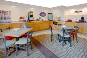 弗里波特的住宿－自由港貝蒙特套房酒店，一间带2张桌子和椅子的餐厅以及一间厨房
