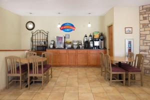 a dining room with a table and chairs and a counter at Baymont by Wyndham Metropolis in Metropolis