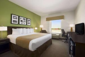 a hotel room with a large bed and a window at PetroStay Inn & Suites Cotulla in Cotulla