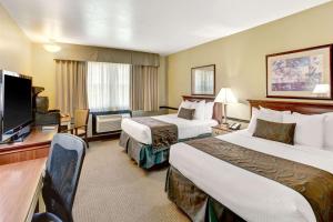 a hotel room with two beds and a flat screen tv at Baymont by Wyndham Provo River in Provo
