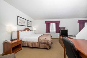 A bed or beds in a room at Baymont by Wyndham Marshfield