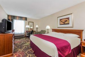 a hotel room with a large bed and a flat screen tv at Baymont by Wyndham Cornelia in Cornelia