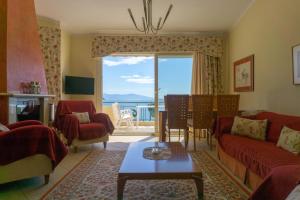 sala de estar con muebles de color rojo y ventana grande en Villa Eirini, en Nea Iraklitsa