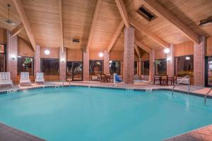 - une grande piscine dans un bâtiment doté d'un plafond en bois dans l'établissement Baymont by Wyndham Marshfield, à Marshfield