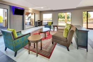 - un salon avec des chaises, un canapé et une télévision dans l'établissement Baymont by Wyndham Terrell, à Terrell
