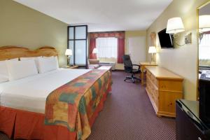 a hotel room with a large bed and a desk at Baymont by Wyndham Terrell in Terrell