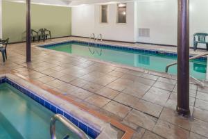 a swimming pool with turquoise water in a building at Baymont by Wyndham Pueblo in Pueblo
