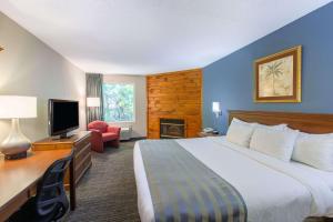a hotel room with a bed and a television at Baymont by Wyndham Bartonsville Poconos in Bartonsville