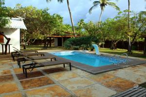 a swimming pool with two benches and a slide at Orla Atins in Atins