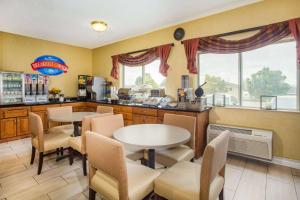 a kitchen with two tables and chairs in a room at Baymont by Wyndham Helena in Helena