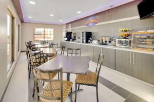 a restaurant with tables and chairs and a kitchen at Baymont by Wyndham Terrell in Terrell