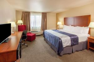 a hotel room with a bed and a desk at Baymont by Wyndham Grand Forks in Grand Forks +37 photos