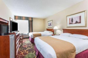 a hotel room with two beds and a flat screen tv at Baymont by Wyndham Cornelia in Cornelia +1 photo