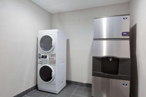 een wasruimte met een wasmachine en droger en een koelkast bij Baymont by Wyndham Bryan College Station in Bryan