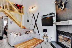 uma sala de estar com um sofá e uma lareira em Condo 304 33 Chemin du Hameau by Les Chalets Alpins em Stoneham