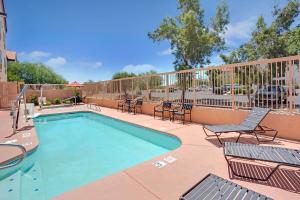 a swimming pool with chairs and a fence with at Baymont by Wyndham Tucson Airport in Tucson