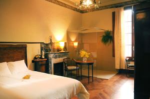 マルグラット・デ・マルにあるCa l'Esparrechのベッドルーム(ベッド1台、テーブル、暖炉付)