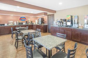 a restaurant with tables and chairs and a counter at Baymont by Wyndham Holland in Holland