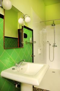 a green bathroom with a sink and a shower at Ca l'Esparrech in Malgrat de Mar