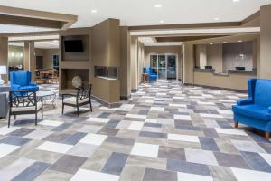 een lobby met blauwe stoelen en een dambord vloer bij Baymont by Wyndham Grand Forks in Grand Forks