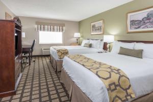 a hotel room with two beds and a flat screen tv at Baymont by Wyndham Fulton in Fulton