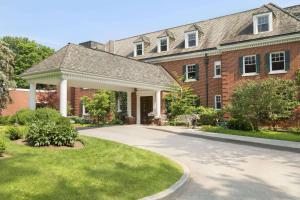 a brick house with a porch and a driveway at Ivey Spencer Leadership Centre, a Dolce by Wyndham in London