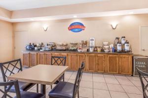 a kitchen with wooden cabinets and a table and chairs at Baymont by Wyndham Cartersville in Cartersville