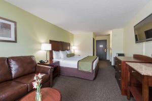 a hotel room with a bed and a couch at Baymont by Wyndham Pierre in Pierre