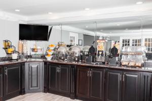 a kitchen with black cabinets and a counter top at Baymont by Wyndham Glenview in Glenview